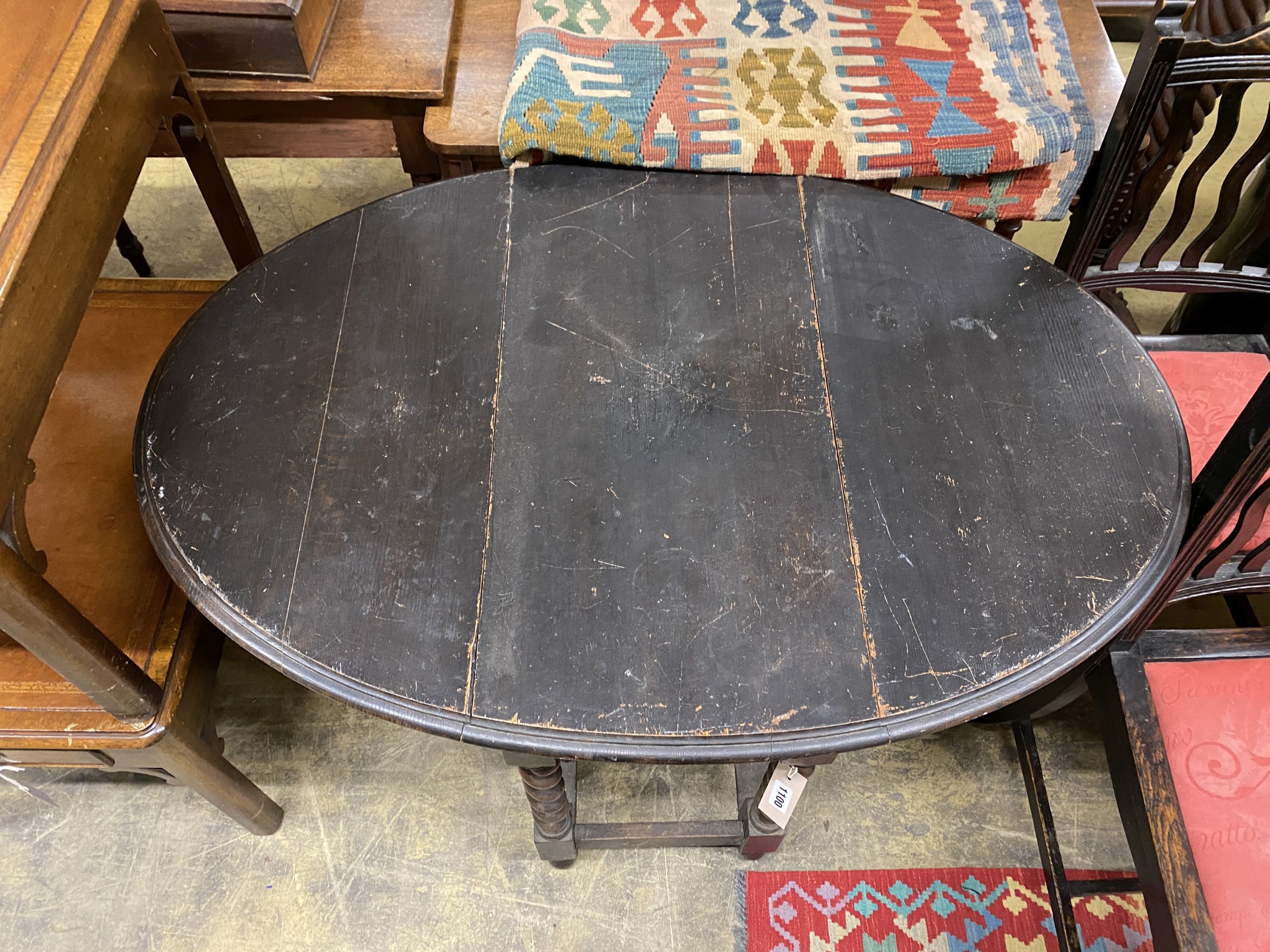 An early 20th century oak oval gateleg table, 106cm extended, width 74cm, height 74cm together with two oak dining chairs